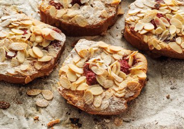 Badem kreması (frangipan) ve fırında pişmiş Brioche dilimlerinden yapılmış ahududu eklenmiş Bostock, yakın görüş. Geleneksel Fransız tostu.. 