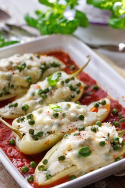 Biberler pirinçle doldurulmuş yeşil bezelye, baharatlı sarımsak, mozzarella peyniri ile pişirilmiş domates sosu, içerideki bibere odaklan.