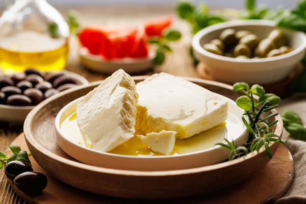 Feta cheese with the addition of olive oil on a ceramic plate, close up view. Traditional Greek product