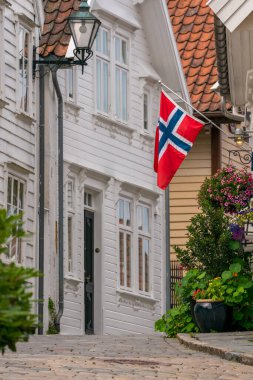 Yamaçlarda kırmızı çatıları ve dar sokakları olan güzel beyaz ahşap evler. Norveç 'in Stavanger şehrinin dar sokakları..