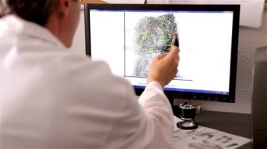 Bir polis bilimi uzmanı, CSI, parmak izi ve eşleşme noktalarını bilgisayar ekranında kontrol eder.