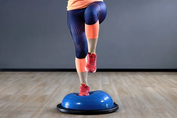 BOSU Ball Balance Training Ball workout. Young woman doing BOSU Ball exercises