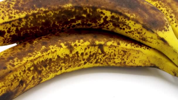 一些没有剥皮的成熟香蕉在白色的背景复制空间 它的皮肤上有斑点 — 图库视频影像