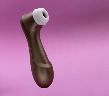 Pembe arka planda izole edilmiş kadınlara zevk vermek için erotik oyuncaklar emmek