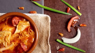 Tipik İspanyol yemekleri tapa callos, Chorizo ve malzemelerinin bir kısmı ahşap bir arka planda.