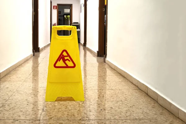 A yellow slippery wet floor sign
