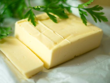 Dilimlenmiş tereyağı ve yeşil maydanozla süslenmiş.