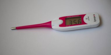 Sıcaklığı ölçmek için dijital gövde termometresi, beyaz arkaplanda 35,6 derece C (Celsius) sıcaklığı gösterir. 08.04.2022 Varşova, Polonya
