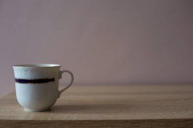 Tahta bir masada bir fincan kahve ya da çay.