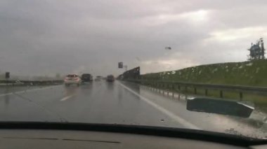 Car wipers removing heavy rain from the windshield during ride. Driving a car in a storm on a highway road. Warsaw, Poland. 20.04.2022