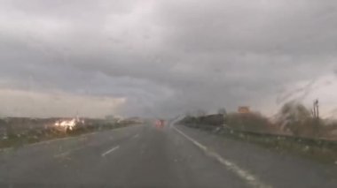 Car wipers removing heavy rain from the windshield during ride. Driving a car in a storm on a highway road. Warsaw, Poland. 20.04.2022
