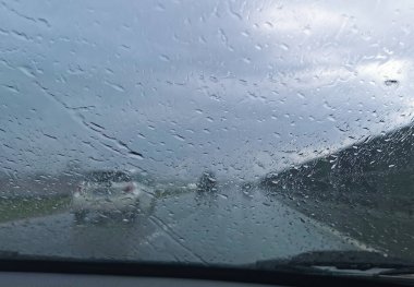 Yağmurda araba sürüyorum. Yağmur fırtınası sırasında arabanın ön camından bakmak