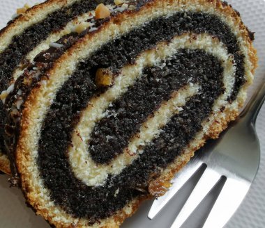 Close up of a piece of poppy seed cake on a white plate