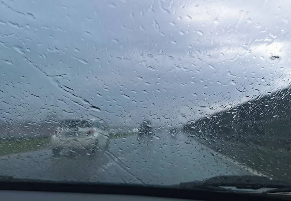 Yağmurda araba sürüyorum. Yağmur fırtınası sırasında arabanın ön camından bakmak