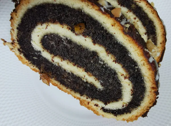 Bir parça haşhaşlı keki beyaz tabakta yakın.