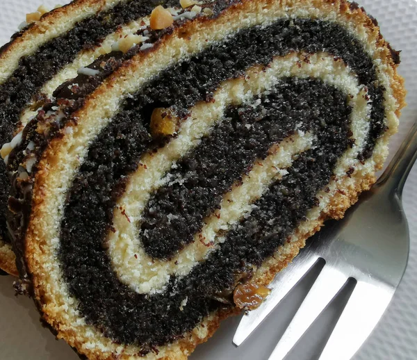 Bir parça haşhaşlı keki beyaz tabakta yakın.