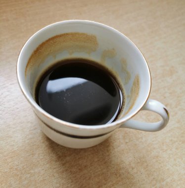 Kahve fincanı, ahşap masa arkaplanının üst görüntüsü.