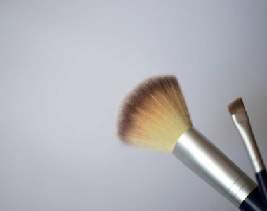 Big and small makeup brush on white background
