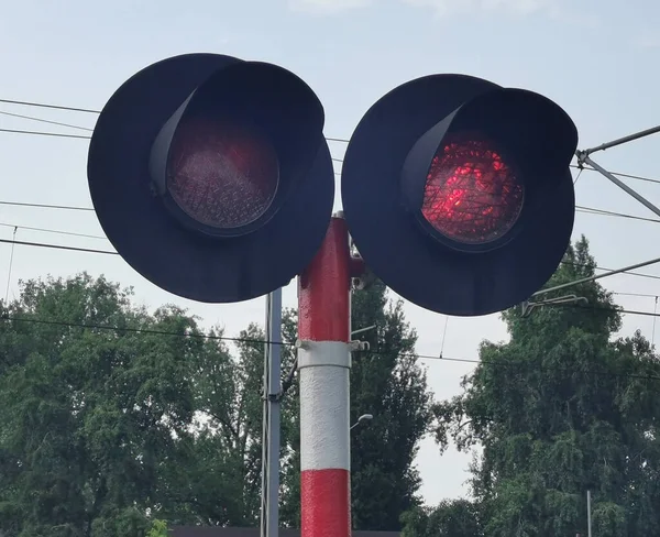 Red traffic light in front of an oncoming train. Red signal stop traffic light train