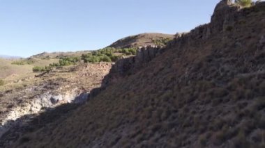 İspanya 'nın güneyindeki dağlık arazide ağaçlar ve çalılar var, gökyüzü açık.