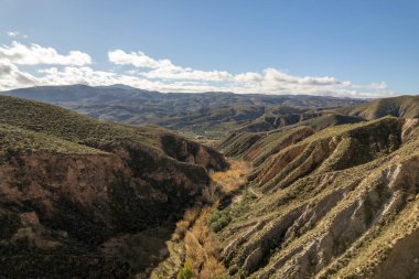 İspanya 'nın güneyindeki dağlık arazide birçok vadi var. Gökyüzünde bulutlar var.