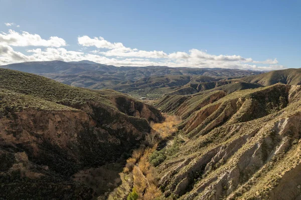 İspanya 'nın güneyindeki dağlık arazide birçok vadi var. Gökyüzünde bulutlar var.