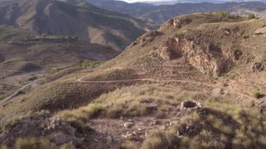 İspanya 'nın güneyindeki dağlık arazi, ağaçlar ve çalılar var, kurak bir bölge, gökyüzünde bulutlar var.