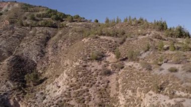 İspanya 'nın güneyindeki dağlık arazi, ağaçların ve çalıların bitki örtüsü, vadiler, gökyüzü açık.