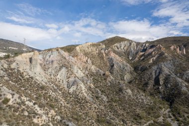 Endülüs 'ün güneyindeki dağlık bölgede ağaçlar, çalılar, vadiler, gökyüzünde bulutlar var.