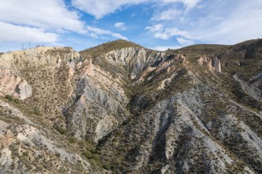 Endülüs 'ün güneyindeki dağlık bölgede ağaçlar, çalılar, vadiler, gökyüzünde bulutlar var.