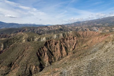 Endülüs 'ün güneyindeki dağlık bölgede ağaçlar, çalılar, vadiler, gökyüzünde bulutlar var.