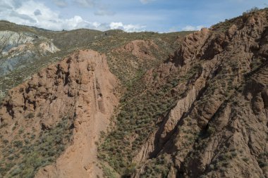 Granada 'nın güneyindeki sarp arazi kurak bir bölge, çalılar var, taşlar ve kayalar var, gökyüzünde bulutlar var.