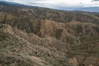 Endülüs 'ün güneyindeki dağlık bölgede ağaçlar, çalılar, vadiler, gökyüzünde bulutlar var.