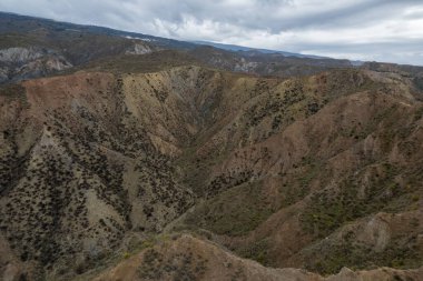 Endülüs 'ün güneyindeki dağlık bölgede ağaçlar, çalılar, vadiler, gökyüzünde bulutlar var.
