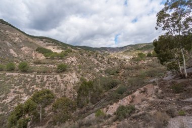 İspanya 'nın güneyinde dağlık bir arazi, bir çam ormanı var, vadiler var, gökyüzü bulutlu