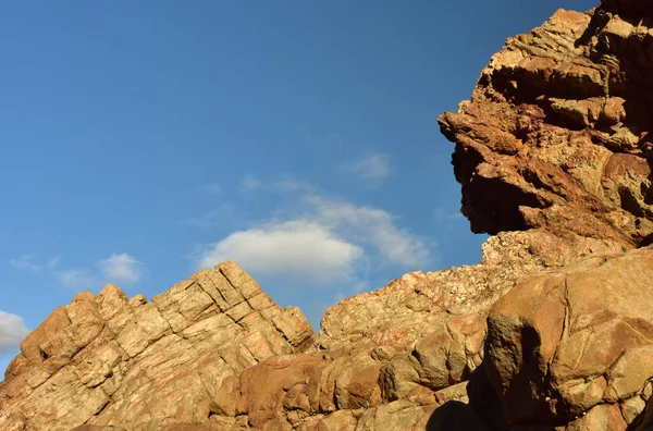 蓝天一种海滨红岩 在蓝天和一些云彩的映衬下 形似人脸 — 图库照片