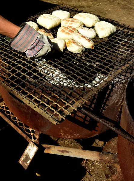 传统的南非罗斯特科克 Roosterkoek 或班诺克 Bannock 在篝火中被烤 — 图库照片