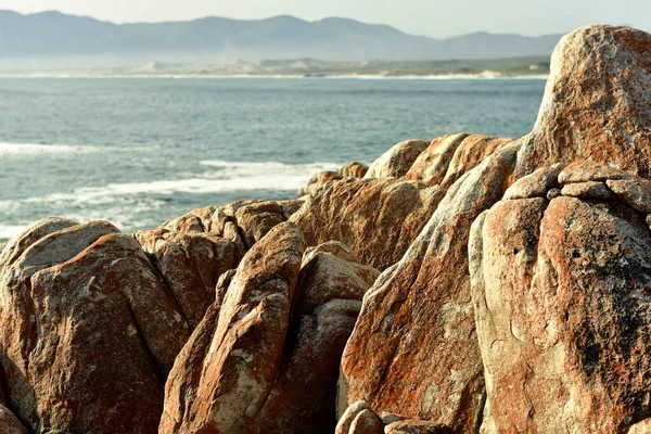 Röda Och Gräddfärgade Klippor Vid Havet Ser Som Skulpturer Med — Stockfoto