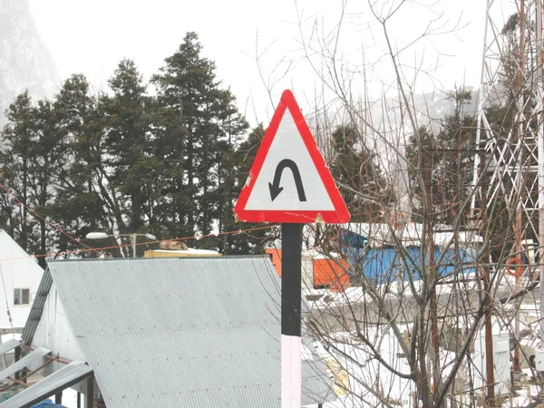 U-Turn Road Signage Board in a mountainous region around a curve mountain