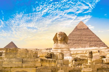 Mısır 'ın Giza şehrinde firavunların, Cheops' ların, Khafren 'lerin ve Mikerin' in piramitlerinin arka planına karşı büyük sfenks.