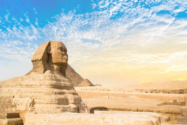 Mısır 'ın Giza şehrinde firavunların, Cheops' ların, Khafren 'lerin ve Mikerin' in piramitlerinin arka planına karşı büyük sfenks.