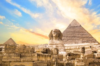 Mısır 'ın Giza şehrinde firavunların, Cheops' ların, Khafren 'lerin ve Mikerin' in piramitlerinin arka planına karşı büyük sfenks.
