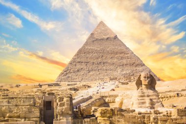 Mısır 'ın Giza şehrinde firavunların, Cheops' ların, Khafren 'lerin ve Mikerin' in piramitlerinin arka planına karşı büyük sfenks.