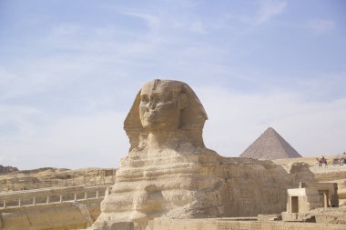 Mısır 'ın Giza şehrinde firavunların, Cheops' ların, Khafren 'lerin ve Mikerin' in piramitlerinin arka planına karşı büyük sfenks.