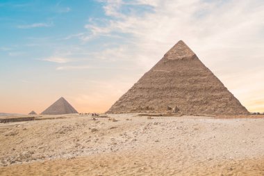 Mısır 'ın Giza şehrinde firavunların, Cheops' ların, Khafren 'lerin ve Mikerin' in piramitlerinin arka planına karşı büyük sfenks.