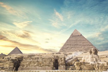 Mısır 'ın Giza şehrinde firavunların, Cheops' ların, Khafren 'lerin ve Mikerin' in piramitlerinin arka planına karşı büyük sfenks.