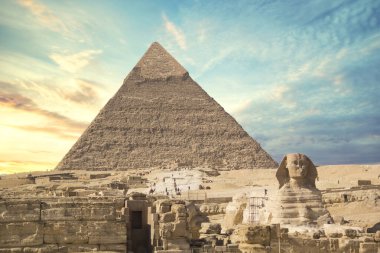Mısır 'ın Giza şehrinde firavunların, Cheops' ların, Khafren 'lerin ve Mikerin' in piramitlerinin arka planına karşı büyük sfenks.