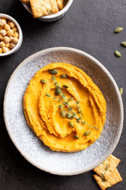 Balkabağı humuslu kase, sebze ve baharatla süslenmiş lezzetli aperatif.