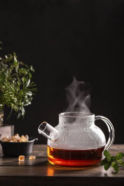 Tahta masada şekerli lolipoplu siyah sıcak çay.