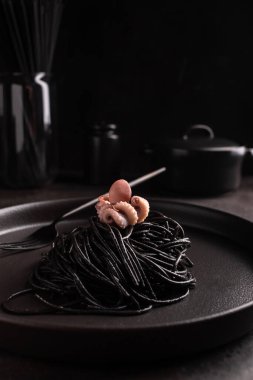 Haşlanmış ahtapotlu mürekkep balıklı siyah spagetti.